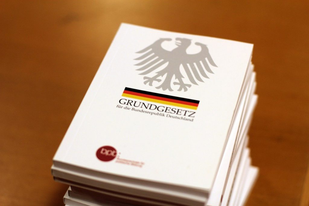 Ein Stapel Bücher, oben drauf das Grundgesetz der Bundesrepublik Deutschland