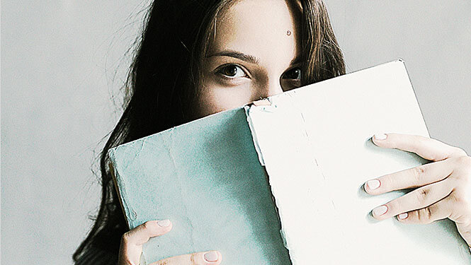 what-we-do-05-free-img junge Frau, die über ein Buch schaut
